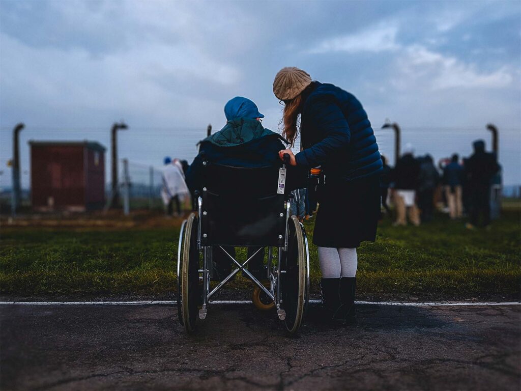 Carer with resident in wheelchair outside