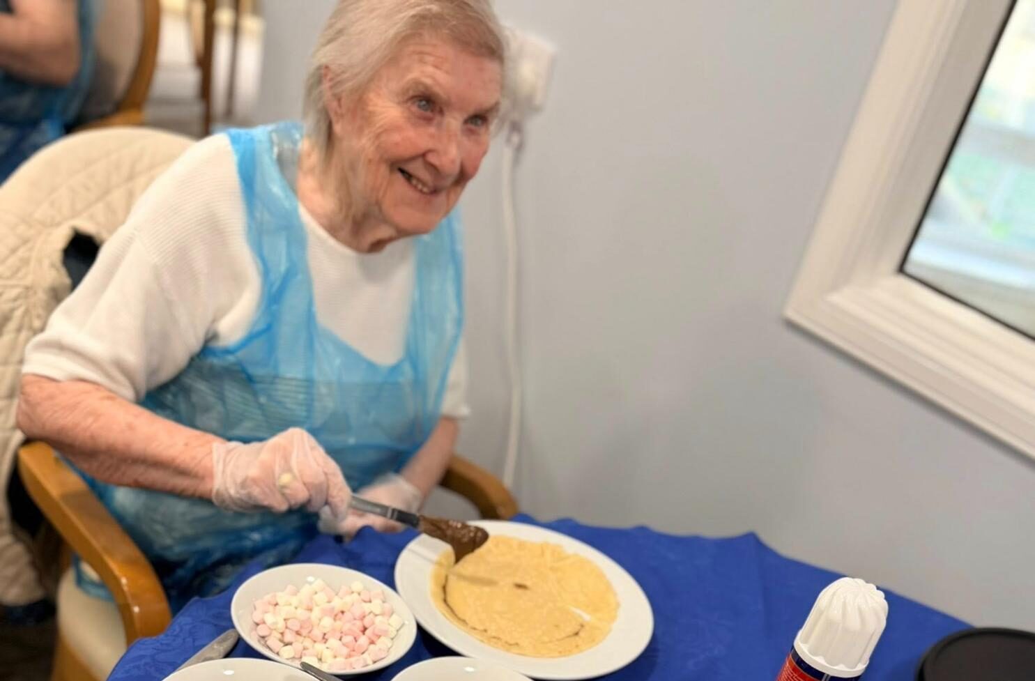 resident smiling while making pancakes