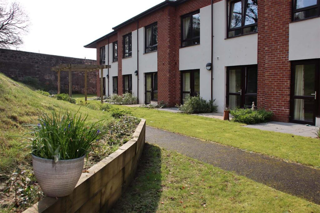 exterior of care home with garden and raised planters