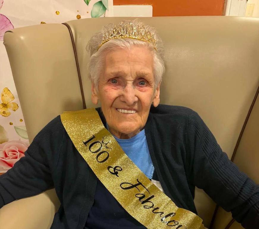 older lady with 100th birthday sash