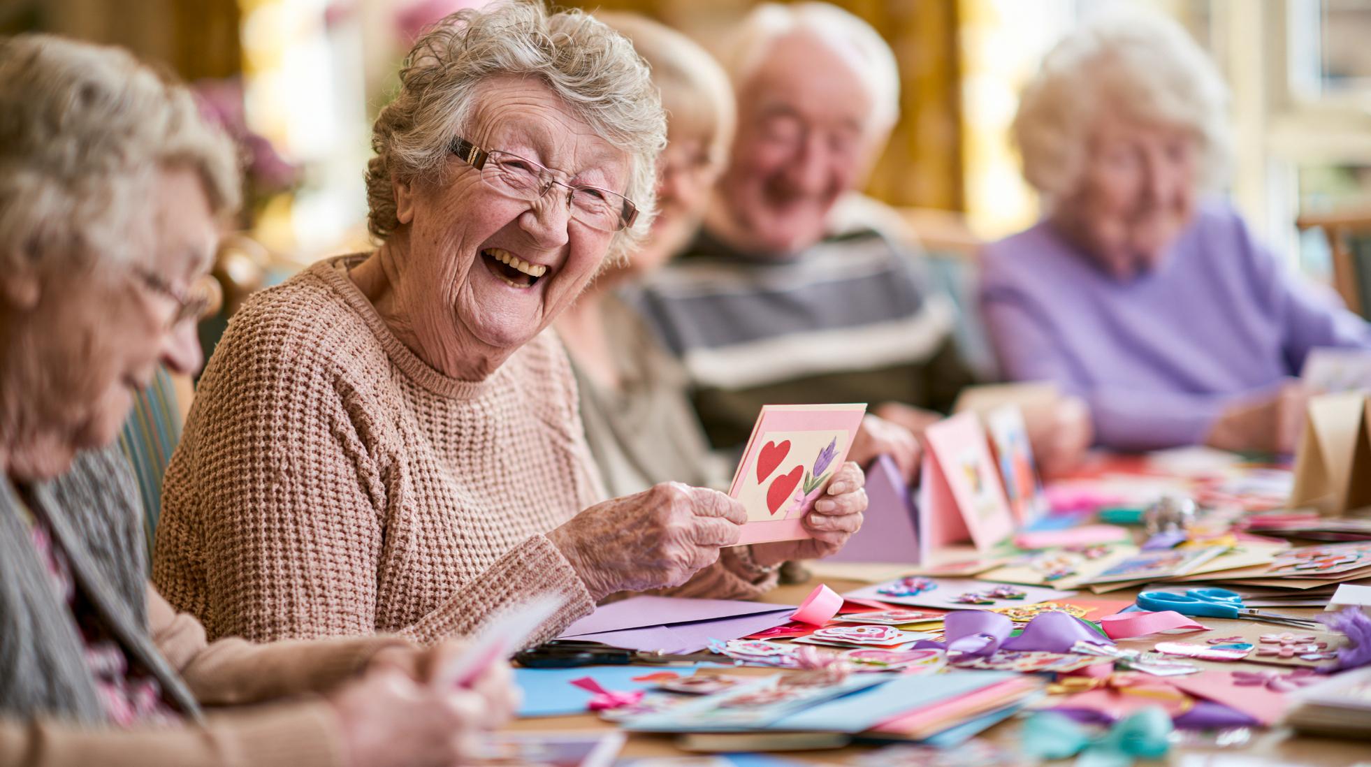 elderly woman laughing during a crafting activity