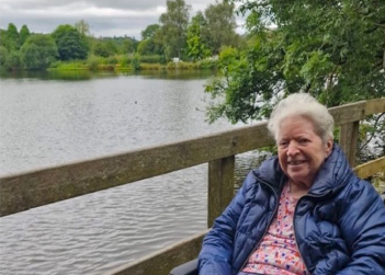 residents wearing a blue coat next to a lake